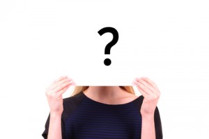 Woman with her face covered by a question mark