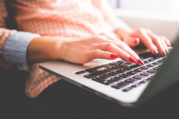 girl typing on macbook