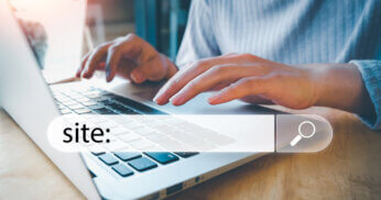 User typing a site search operator on laptop.