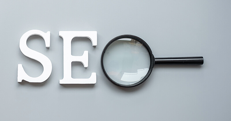 Letters spelling out "SEO" with a magnifying glass for the letter "O."