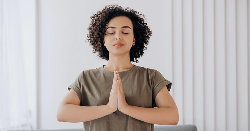 Woman in prayer stance concentrating on achieving SEO project management bliss.