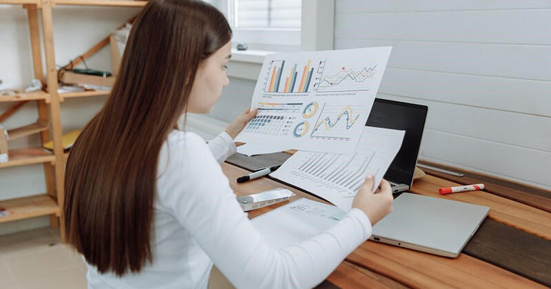 Woman reviewing data and analytics at a desk.
