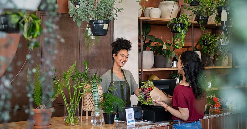 Woman purchasing flowers at a local flower shop.