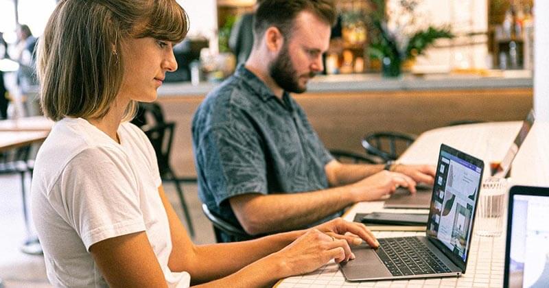 Coworkers sitting at a table together optimizing a website.