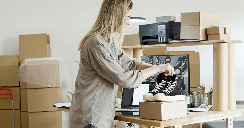 Woman holding shoes purchased from e-commerce website. 