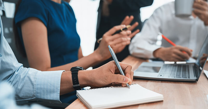 Professional taking notes during a meeting.