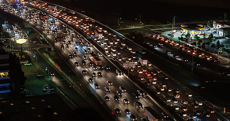 Cars stuck in traffic on a highway at night.