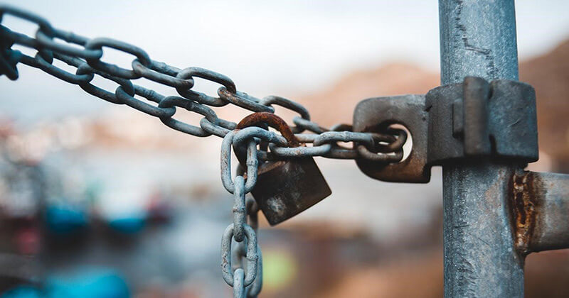 Chain link locked around a metal post.