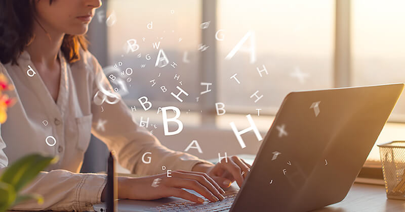 Woman types copy on a laptop, various alphabet letters float around her.