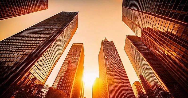 Sun setting behind city skyscrapers.