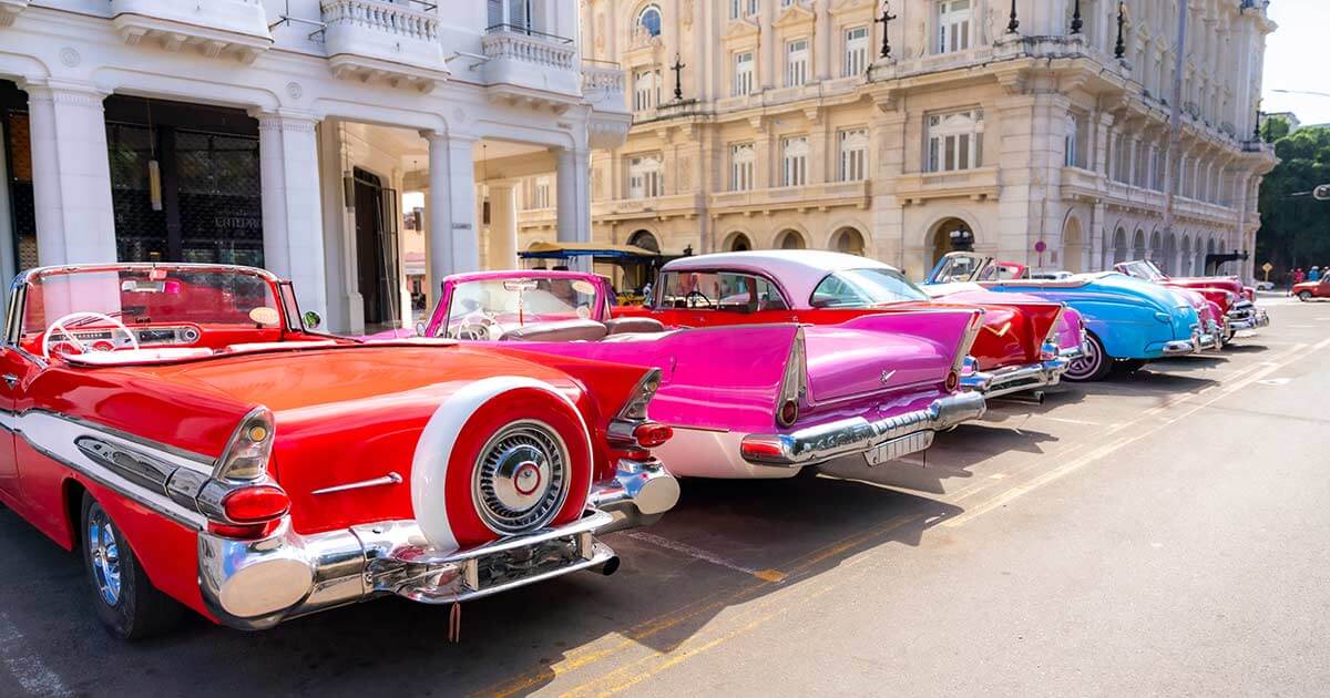 a row of brightly colored classic American cars.