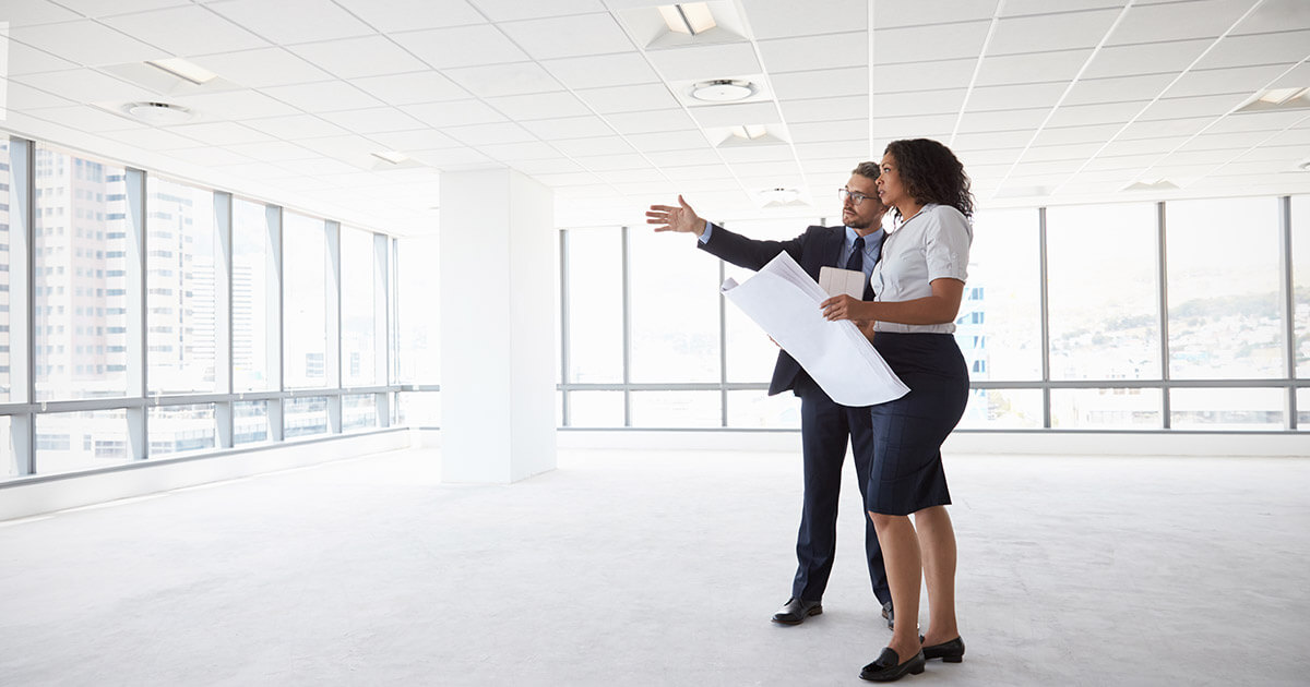 businesspeople meeting in empty office reviewing plans.