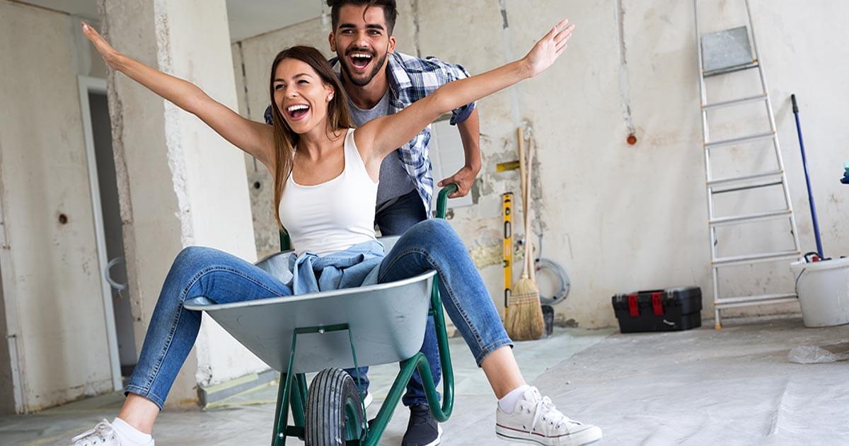 young couple having fun while renovating house.