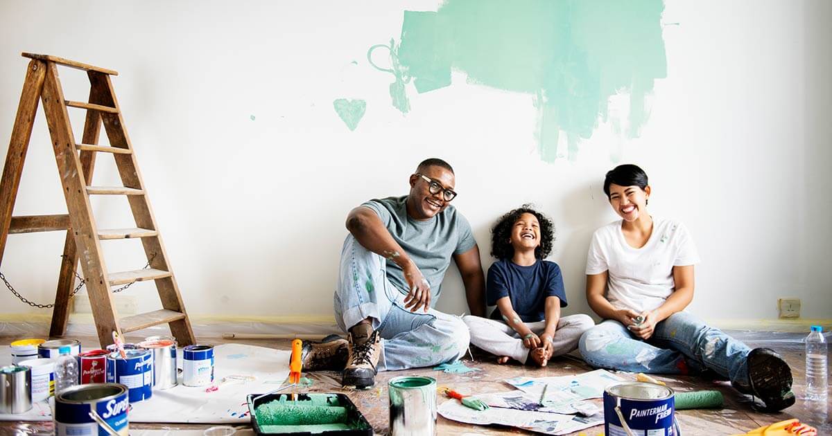happy African American family taking a break from painting wall.