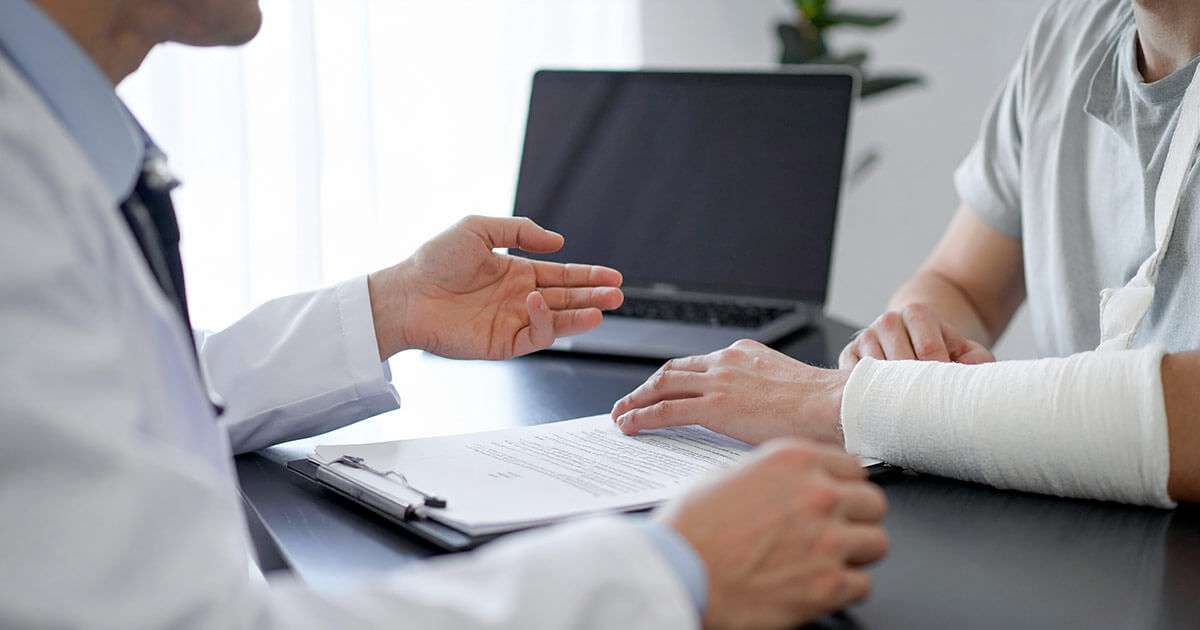 injured person wearing cast on arm meeting with personal injury lawyer.