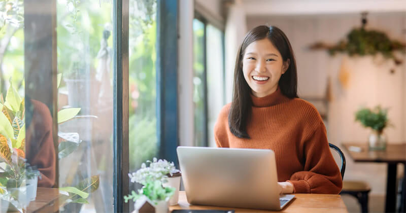 Smiling woman working on laptop.