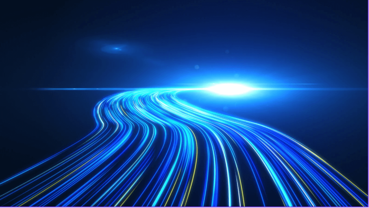 A futuristic digital illustration of bright blue and yellow light trails curving forward into a glowing point on a dark background, symbolizing speed and technology.