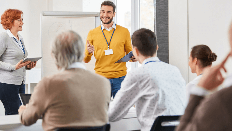 SEO trainer leading a workshop, presenting search optimization strategies to a group of professionals in a classroom setting.
