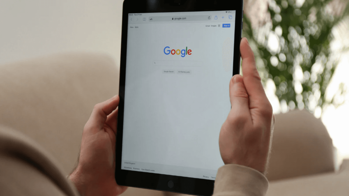 Person holding a tablet displaying the Google homepage, emphasizing the importance of search in B2B research and vendor discovery.