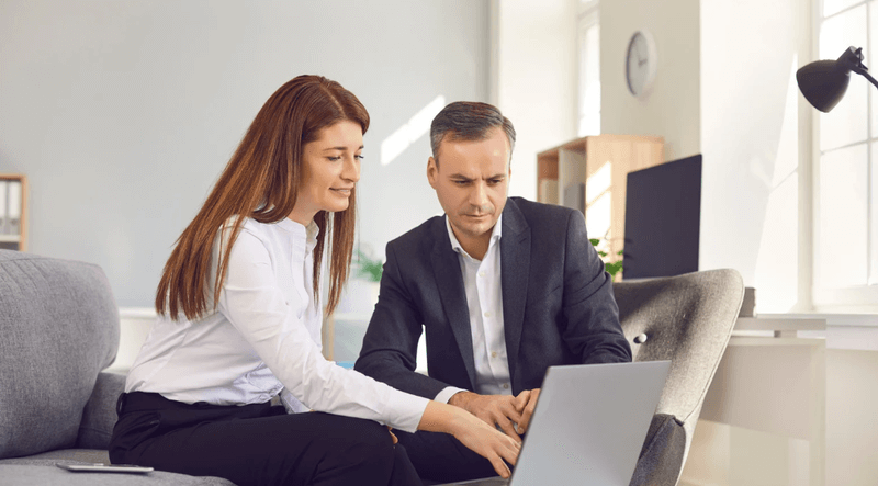 B2B marketing team reviewing digital strategy on a laptop to improve lead generation and customer acquisition.