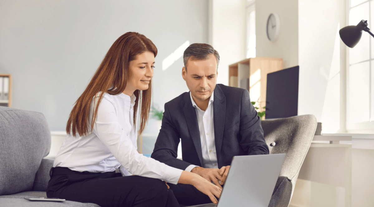 B2B marketing team reviewing digital strategy on a laptop to improve lead generation and customer acquisition.