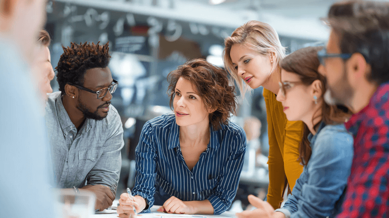 Marketing and SEO professionals collaborating around a table, discussing strategy and data in a modern office environment.