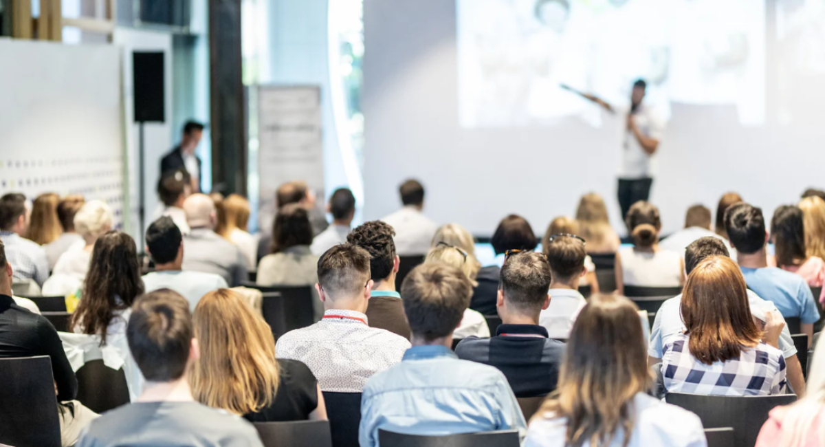 Audience seated and listening to a speaker during a business presentation or conference session
