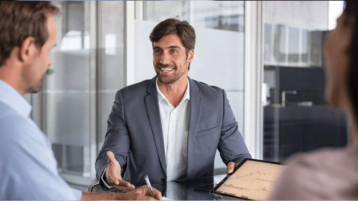 SEO consultant discussing website performance data with clients during a business meeting at a conference table