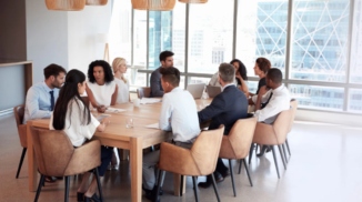 A group of people sitting at a table having a meeting.