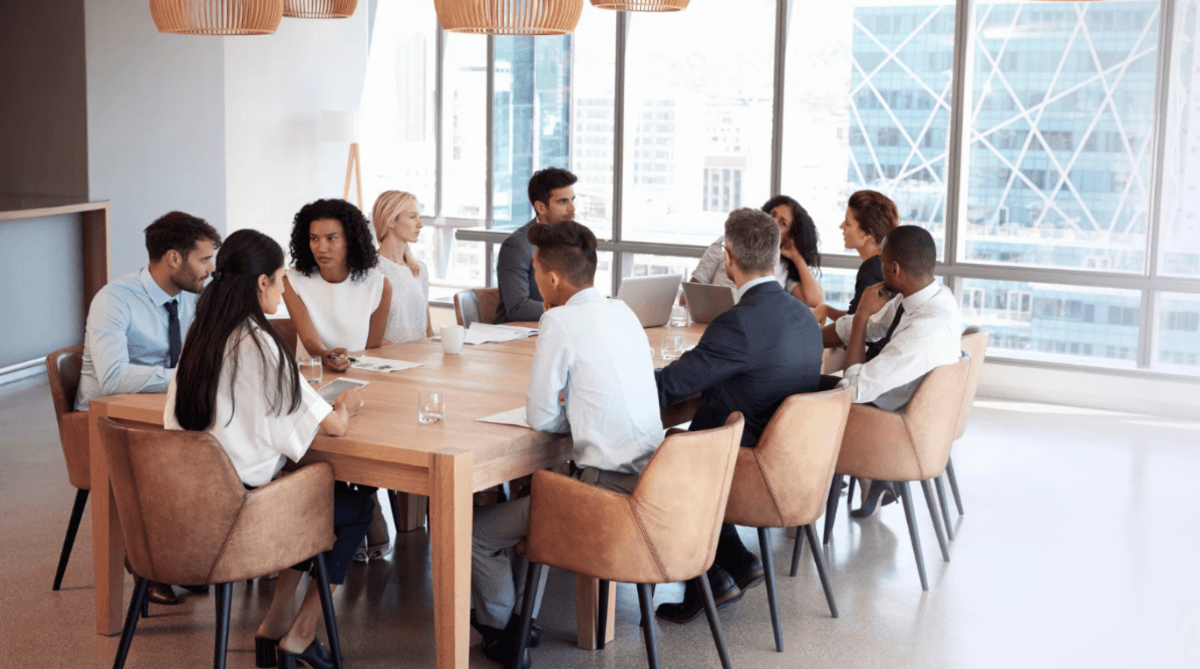 A group of people sitting at a table having a meeting.