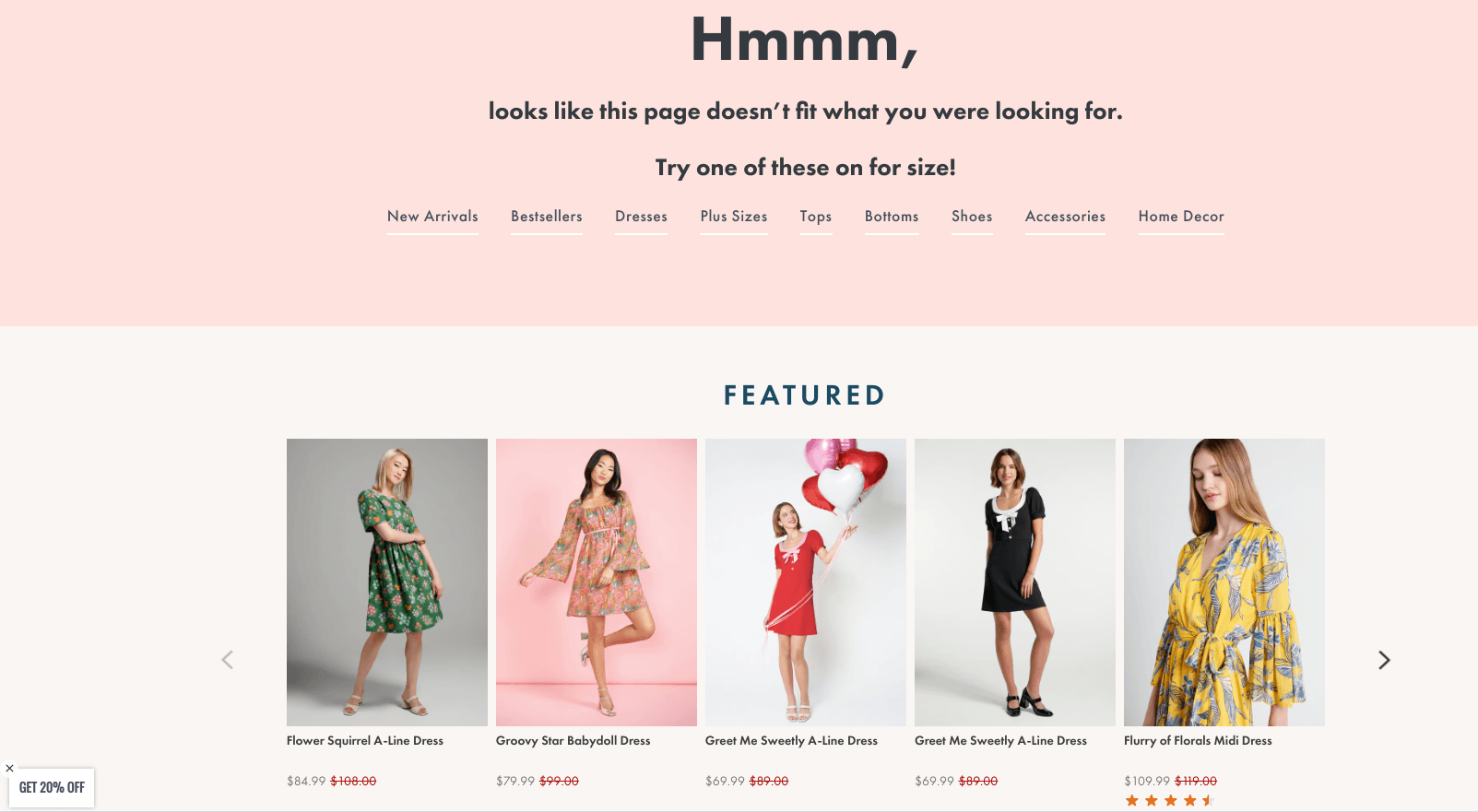 An e-commerce clothing store custom 404 error page reading "Hmmm, looks like this page doesn’t fit what you were looking for" above a "Featured" product grid showcasing various women's dresses.